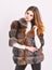 Female brown fur coat. Fur store model posing in soft fluffy warm coat. Pretty fashionista. Fur fashion concept. Woman