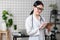 Female brunette doctor wears glasses using tablet, intelligent and lovely woman with the gadget and stethoscope in the