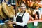 Female brunette selling jamon in delicatessen store