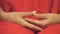 Female buddhist in colorful red robe prepares for meditation, hands crossed