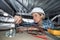 Female builder fixing electricity in roof