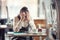 Female busines owner holds her head in hands in desperation over paperwork and tax declaration in a closed pub