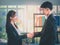Female Business officer shaking hand with a male businessman in office