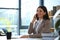 Female business trainer talking on phone while working with laptop