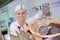 Female butcher showing assortment salami at shop