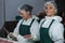 Female butchers maintaining records over digital tablet