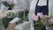 Female buyer buys beautiful bouquet of flowers in a modern flower shop using smartphone for contactless payment on