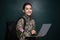 Female cadet with backpack and laptop near chalkboard. Military education