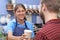 Female Cafe Worker Serving Customer With Takeaway Coffee