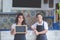 Female cafe worker smiling and holding blank blackboard