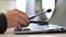 A female call center operator removes the headset and puts it on the laptop keyboard at the end of workday. Woman`s hand