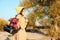 Female camper with backpack and sleeping bag in wilderness.