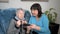 Female caregiver teaching a retired woman how to use a smartphone