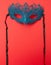 Female carnival mask on a red background. Mystery, incognito, seduction concept. Place for your text