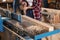 Female carpenter cleaning surface planer with air blow gun in workshop