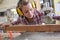 Female carpenter cutting wood with electrical jigsaw