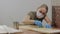 A female carpenter, designer, wearing a medical mask on her face, covers the wooden surface with oil.