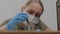 A female carpenter, designer, wearing a medical mask on her face, opens a jar of wood processing oil.