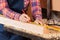 Female Carpenter Marking Wood With Pencil