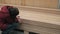 Female carpenter picks out planks in a construction shop