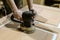 Female carpenter polishes the wooden door surface with electric grinding machine