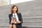 Female caucasian administrator sitting on stairs with tablet and working.