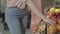 Female Caucasian hands taking yellow tomatoes from shelf and putting vegetables in plastic bag. Vegan woman buying