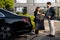 Female chauffeur gives a businessman his suit, after a business trip by car