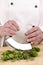 Female chef cuts fresh herbs with a herb chopper