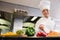 Female chef cutting vegetables in kitchen