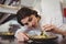 Female chef examining appetizer plate at order station