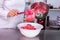 Female chef holding spatula with pink meringue in hand