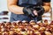 Female Chef Putting Ingredients of Burgers on a Sliced Bread Spread on a Table in Black Gloves