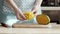 Female Chef`s hands slice mango on wooden cutting board. Summer healthy vegan fruits salad.