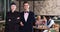 Female chef with waiter welcoming guests of restaurant