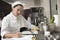 Female Chef Writing On Clipboard In Kitchen