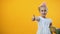 Female child in bunny ears headband holding Easter basket and showing thumbs up