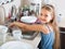 Female child cleaning dishware at home