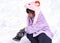 Female child while playing and crawling snow in a ski resort
