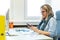 Female child therapist in an office during a phone call, using online calendar to schedule patients appointments. Calendar Planner