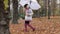 Female child is walking under an umbrella.