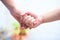 Female childâ€™s hand holding the hand of elder male shot with bokeh background and horizontal. Concept of fatherâ€™s day