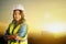 Female Civil Engineer with safety equipment with sunset city golden sky in the background