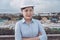 Female Civil Engineer in Safety Hard Hat Standing Against With Construction Site Background. Portrait of Professional Construction