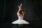 Female classical ballet performer sitting on floor