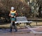 Female cleaner makes wet cleaning paths in the Park