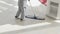 a female cleaner washes floors with a mop in the office or sales floor.