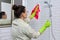 Female cleaning polishing shower glass with a washcloth with microfiber