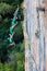 Female Climber falling down from Top of high colorful rocky Wall