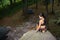 Female climber sitting on big natural boulder in the forest